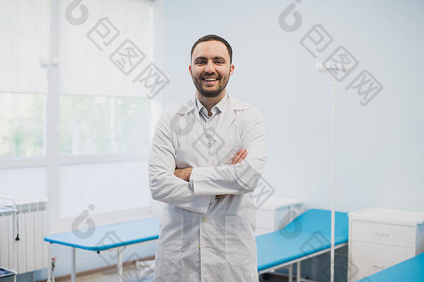 一位快乐的男医生双臂交叉站在医务室的肖像