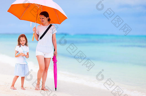 妈妈。女儿走色彩斑斓的橙色伞白色沙子热带海滩多雨的一天