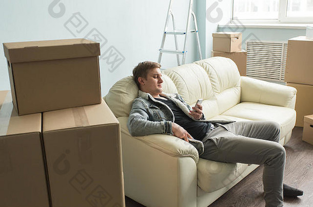 移动过程真正的房地产首页概念累了的家伙坐在沙发空房间