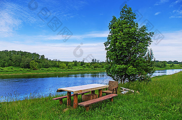 乡村景观。河边的桌子和长凳。