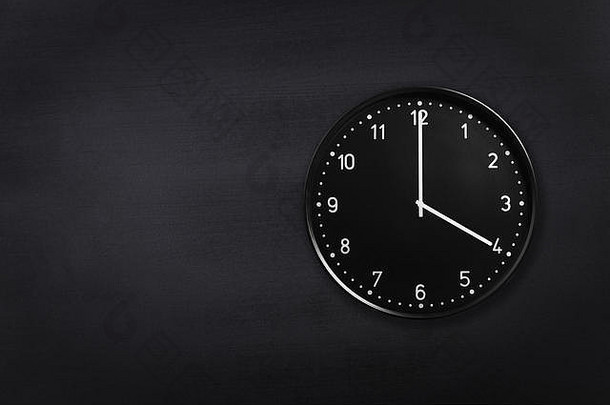 在黑色黑板背景上显示四点钟的挂钟。黑色纹理上显示凌晨4点或下午4点的办公时钟