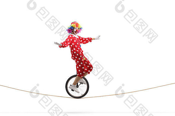 完整的长度配置文件拍摄小丑骑独轮脚踏车绳子孤立的白色背景