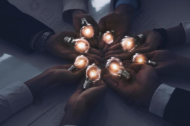 团队合作和头脑风暴的概念与商人分享一个想法与一盏灯。创业理念