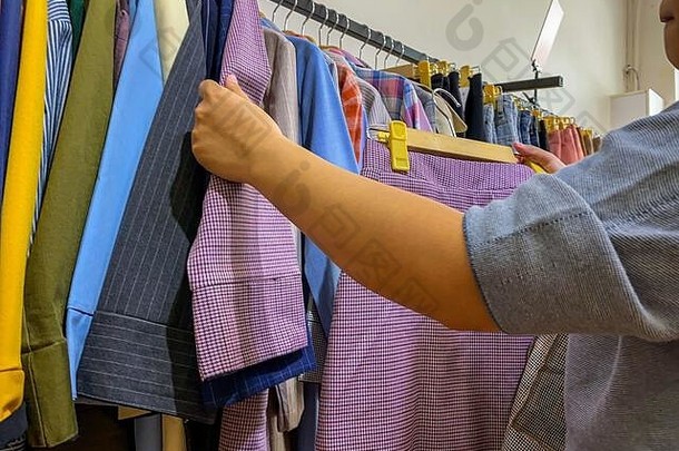 在零售店购物时，女士亲手挑选服装