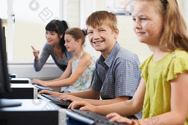 男小学生与老师一起上计算机课