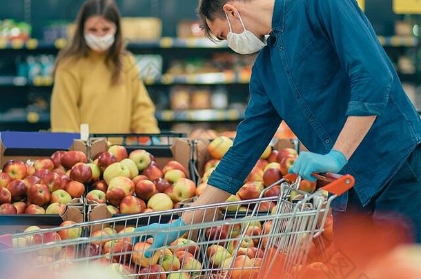 一男一女戴着防护面具在超市购物。