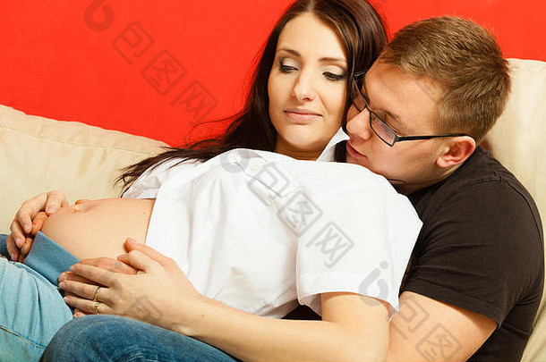 家庭休闲时间期待婴儿概念怀孕了女人男人。放松沙发