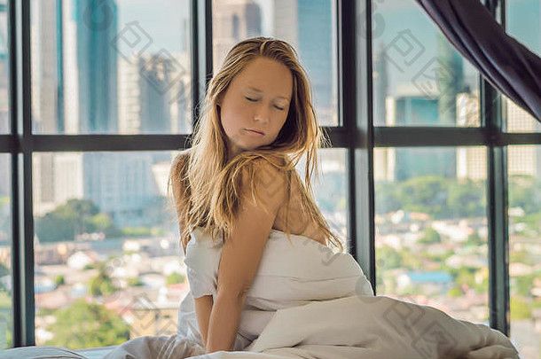 女人醒来早....公寓市中心区域视图摩天大楼生活噪音大城市概念
