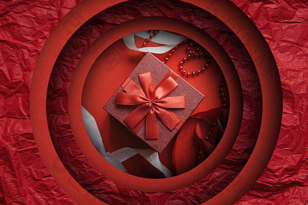 红色背景上印有礼物的红色盒子。情人节、妇女节或任何节日的概念。剪纸