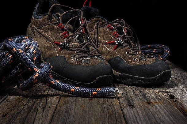 木制背景上有绳子的登山鞋
