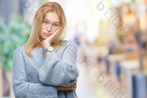 一位年轻的白人妇女，穿着冬衣，在与世隔绝的背景下思考，双臂交叉，看起来很疲惫，对抑郁症感到厌烦。