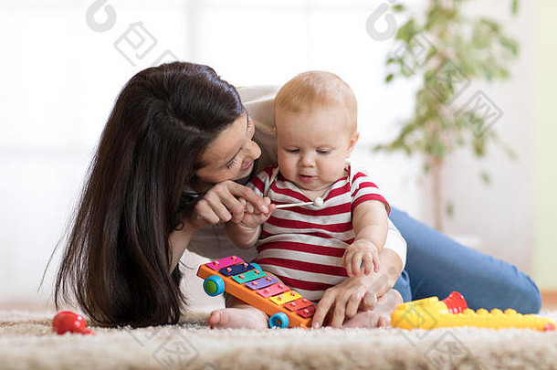可爱的妈妈和小男孩在家里一起在室内玩耍