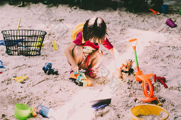 在热<strong>带</strong>海滩上玩耍的孩子。小女孩在海边挖沙。家庭暑假。孩子们玩沙玩具。<strong>带小孩</strong>旅行