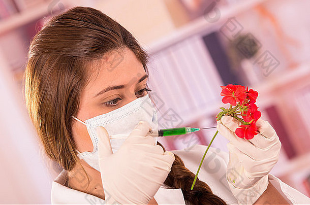 年轻的女生物学家正在用红花做<strong>实验</strong>