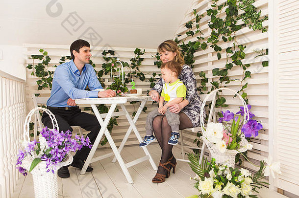 家庭，亲子关系，生日快乐和节日概念-快乐的父母和孩子在桌边喝茶和吃蛋糕。