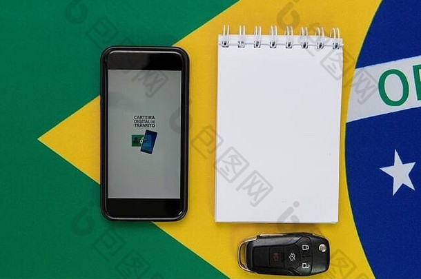 弗洛里亚诺波利斯，巴西。2020年6月27日：带巴西数字<strong>交通卡</strong>（Digital Traffic Card）的手机俯视图，旁边是太阳镜、记事本、，