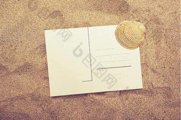 热沙滩沙滩上的空白明信片和海贝壳，在一封信中暑假信息的顶视图，复古到
