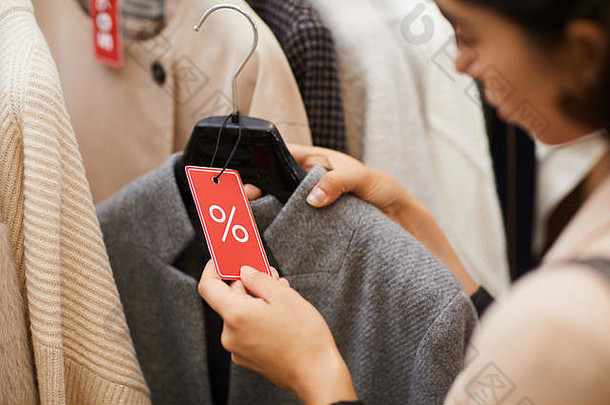 特写镜头认不出来女人持有秋天外套红色的出售标签浏览衣服购物购物中心黑色的星期五复制空间
