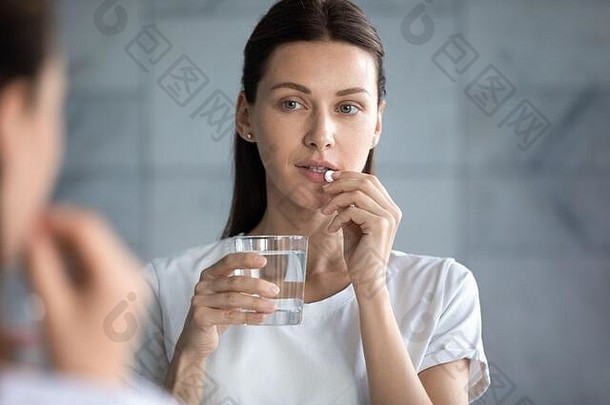 头像中了一个正在吃药的漂亮女人，她在镜子里看着