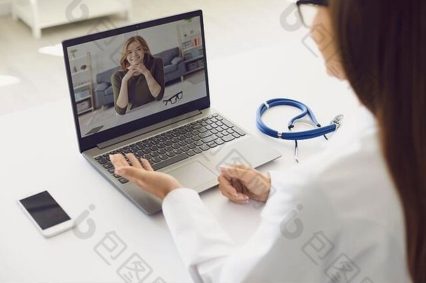 医生和病人在线。女医生带着笔记本电脑咨询患者诊断视频聊天电话聊天坐在诊所的工作场所。
