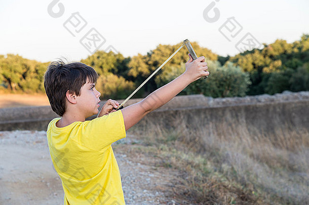 十岁的孩子准备在森林里发射弹弓