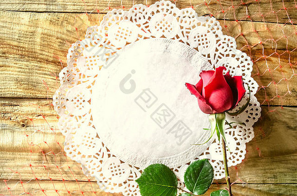 花蕾红玫瑰在白色开敞餐巾的背景上