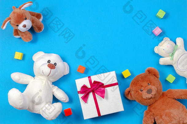 儿童玩具背景。蓝色背景上的泰迪熊、礼品盒和其他玩具