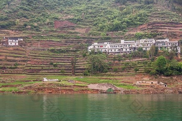 中国武昌——2010年5月7日：大宁河上的翡翠峡谷。村庄的白色房屋建在绿色水面上的棕色梯田上