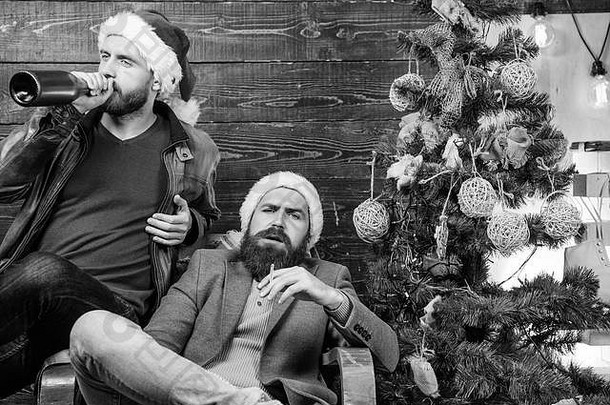 残暴的男人在圣诞树旁庆祝新年。年底前要改掉坏习惯。改掉<strong>有害</strong>的习惯。如何改掉坏习惯。男人喝香槟，抽烟。新年决议。
