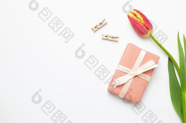 白色背景上有红色郁金香花的礼盒。花卉构图、平面布局、俯视图、空间