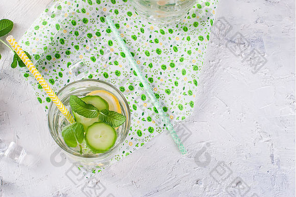 清爽的黄瓜鸡尾酒、柠檬水、解毒水装在白色背景的玻璃杯中。夏日饮料。俯视图