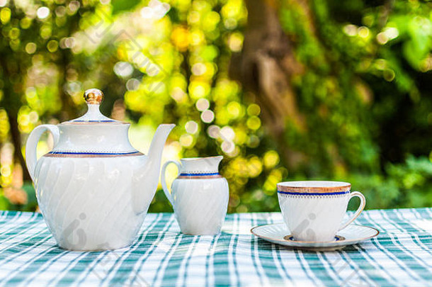 在花园里吃早餐，桌上放着茶具