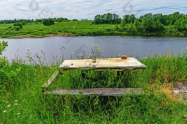 乡村景观。河边废弃的桌子和长凳。