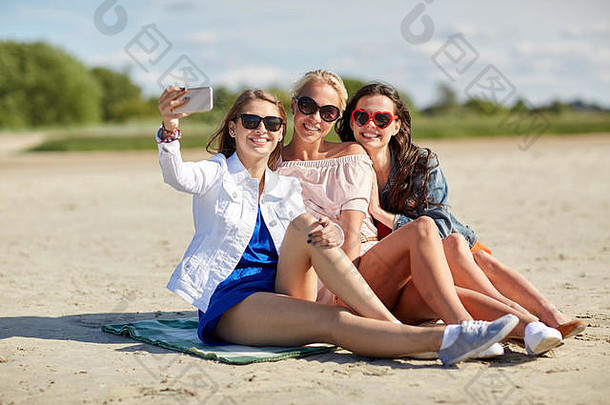 一群微笑的女人在海滩上自拍