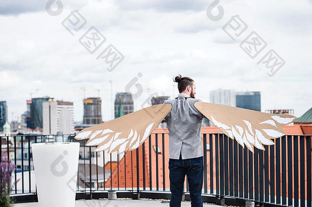 一位年轻的商人站在阳台上，<strong>展翅飞翔</strong>。