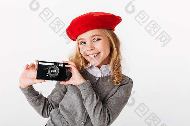 一个穿着制服的快乐小女生的肖像，手持复古相机，隔离在白色背景上