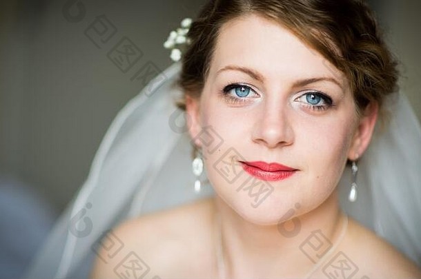一位年轻美丽的未来新娘在准备婚礼、准备婚礼、由专业人士做头发和化妆的过程中为她的婚礼做准备