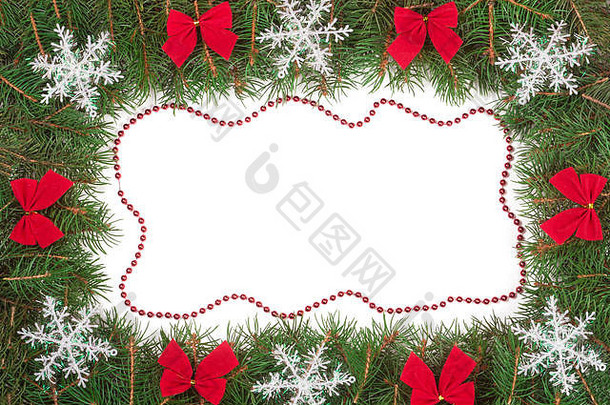 圣诞框架，由冷杉树枝制成，装饰有蝴蝶结和雪花，在白色背景上隔离开来