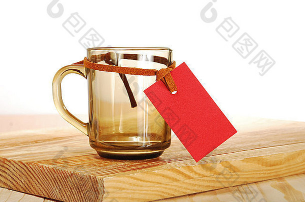 木桌上挂着红色标签的空杯子
