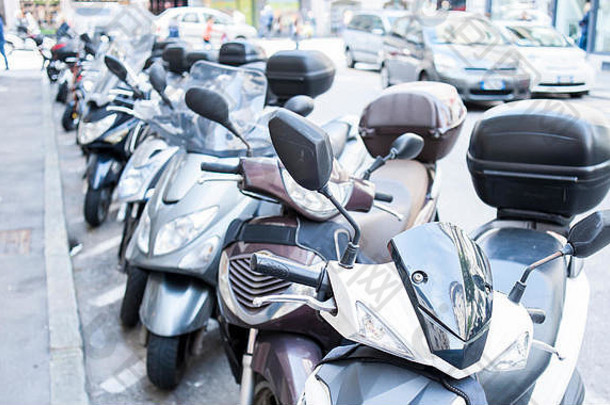 意大利的里雅斯特——2016年4月22日：摩托车、摩托车和滑板车停在城市街道的一排。