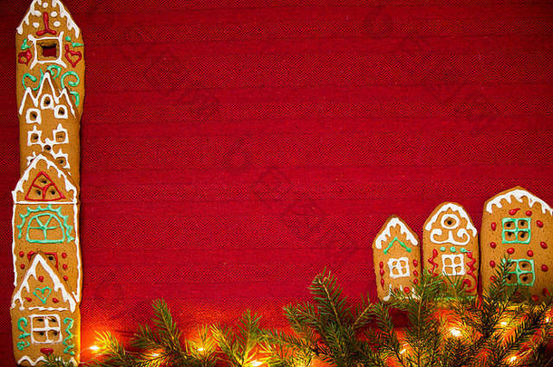 圣诞节背景红色的表格布小镇可爱的姜饼房子装饰糖衣圣诞节灯闪闪发光的冷杉树分支机构