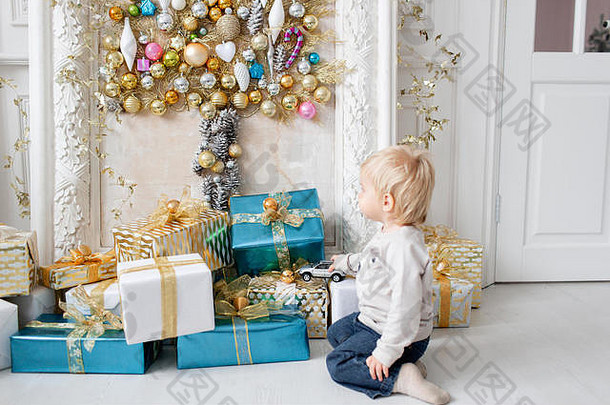 男孩站很多礼物快乐一年装饰圣诞节树圣诞节早....明亮的生活房间