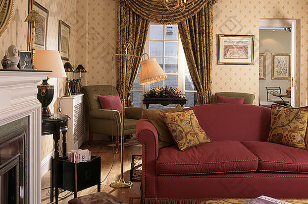 90年代老式客厅里的红色沙发，有花边窗帘和图案壁纸