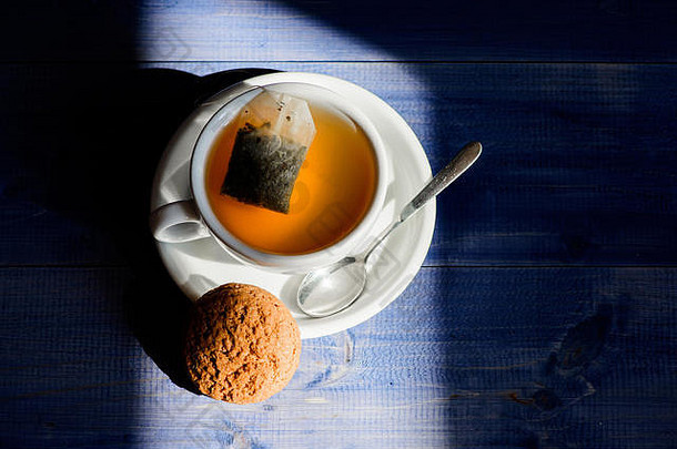 工艺茶冲泡陶瓷杯。灵感和平静的心情。放松甘菊茶。一杯热茶和燕麦饼干。快餐概念。杯子里装满了茶。草本植物的绿色或黑色全叶。