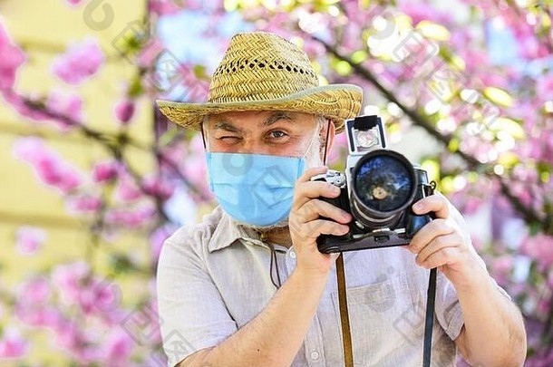 流感大流行概念有风险的摄影师工作花粉过敏旅游相机照片自然摄影高级男人。呼吸器面具专业摄影师工作冠状病毒检疫