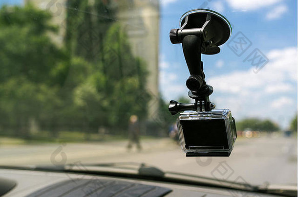 在汽车挡风玻璃窗上带吸帽的动作摄像机，拍摄城市交通环境中的驾驶体验