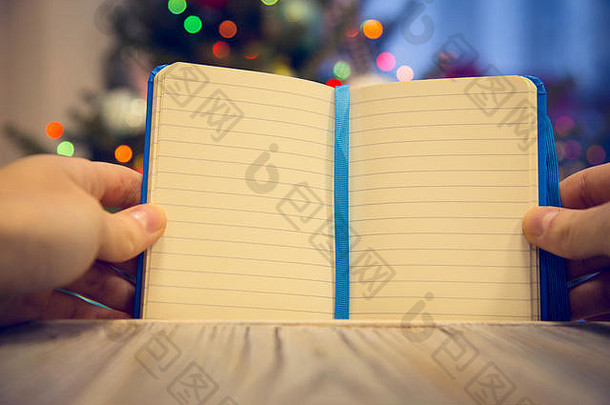 手持有打开笔记本木表格装饰圣诞节树