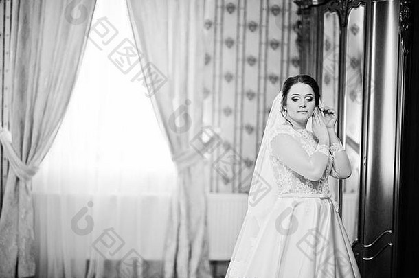 <strong>婚礼</strong>当天，年轻的黑发新娘在她的房间里摆姿势。黑白照片
