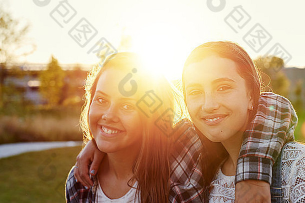 两个十几岁的女孩在一个夏天的晚上在太阳耀斑外