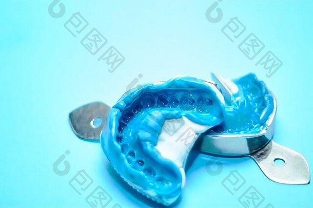 蓝色背景上的两个牙科印模，带有复印空间。牙科模具由上下颚硅材料制成。